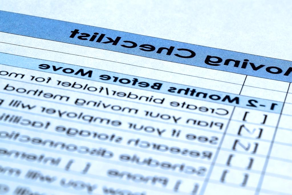 Person crossing out paid debts on a handwritten payoff checklist